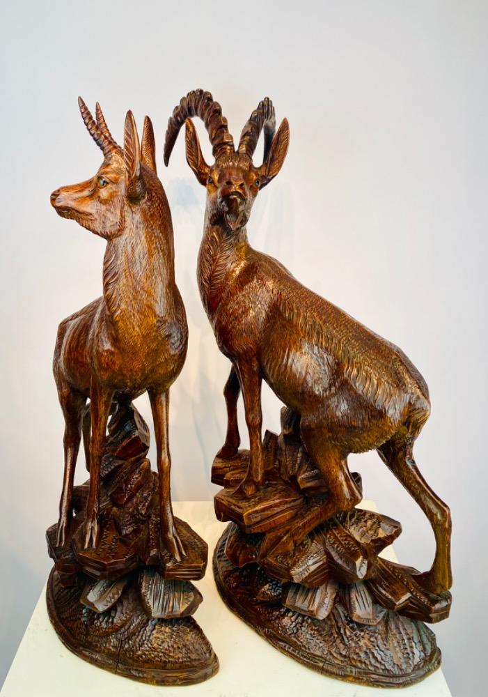 Pair large late 19thC Black Forest carved wood chamois with glass eyes.